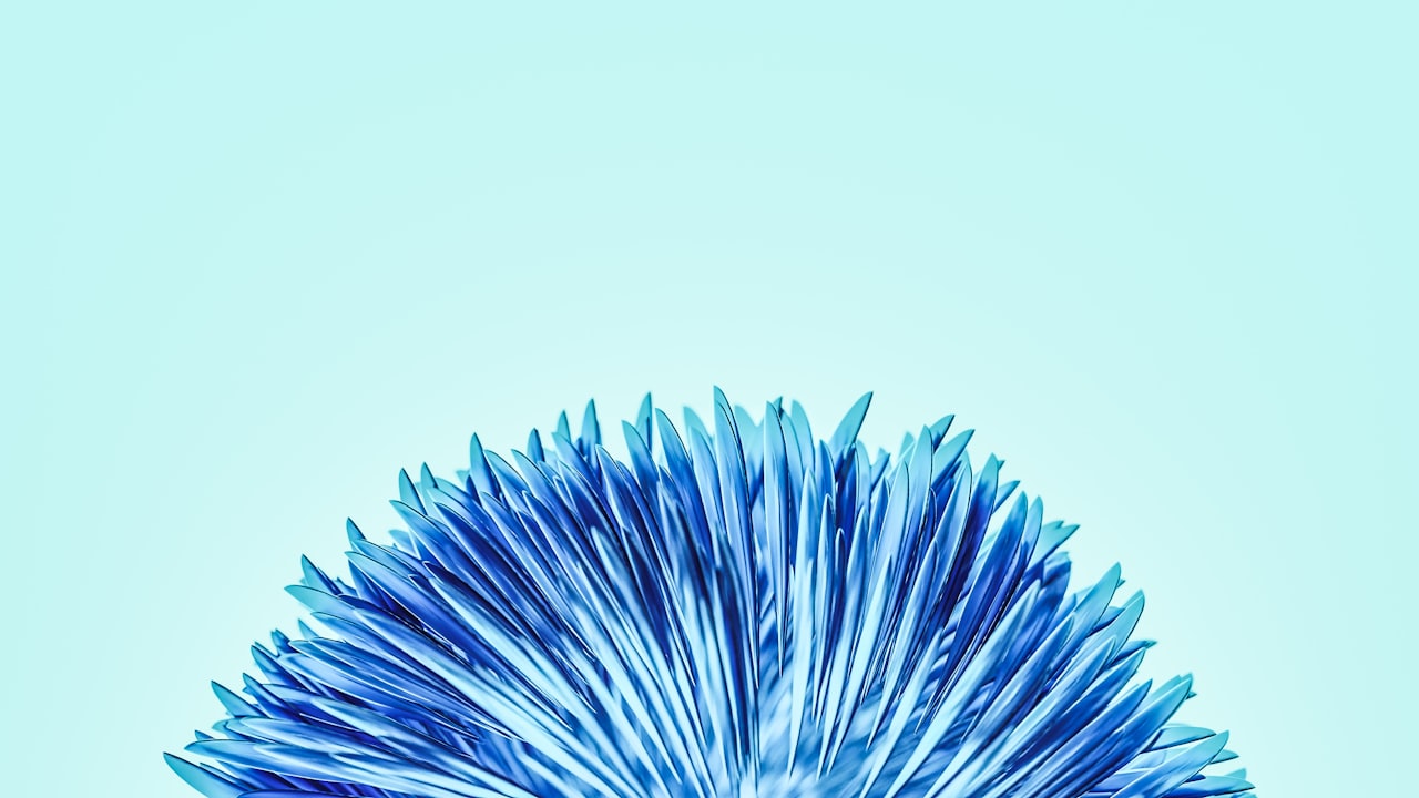 Abstrakte blaue Blume mit kristallartigen Spitzen und einer schwebenden Kugel auf hellblauem Hintergrund