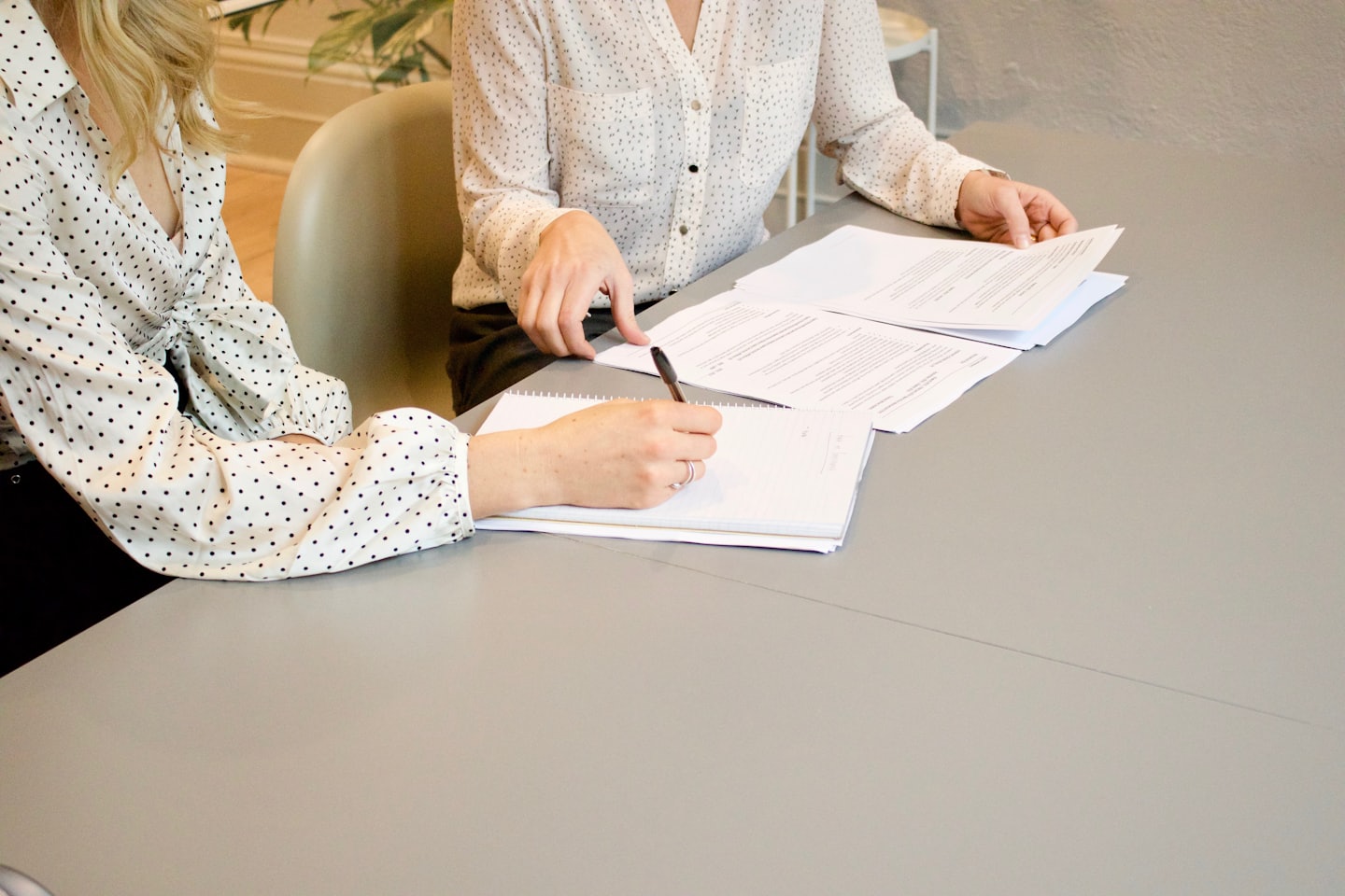 Zwei Personen im Gespräch über Unterlagen – symbolisch für Information und Orientierung rund um Therapie und Rahmenbedingungen
