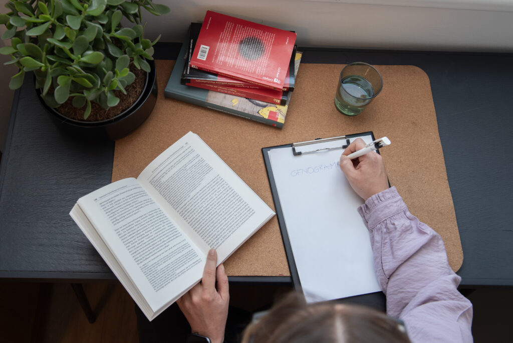 Arbeitsplatz der Therapeutin mit Buch, Notizen und inspirierender Umgebung
